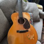 Pre war 1940 000-18 guitar sitting on a couch