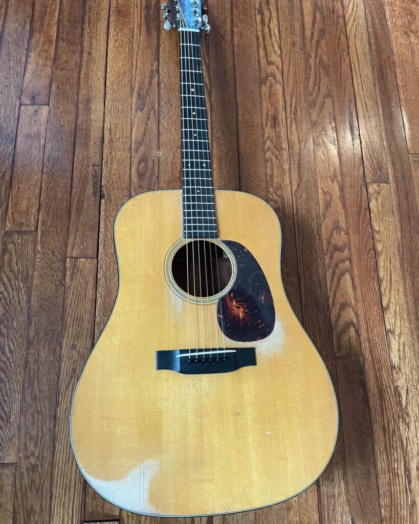 A 1941 D-18 guitar laying on a wooden floor